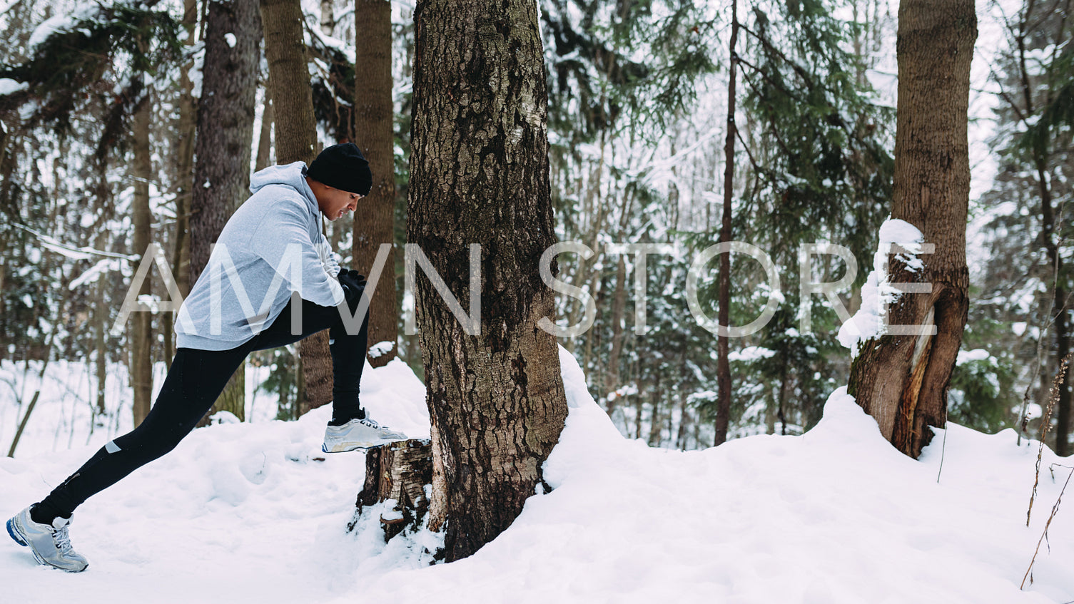 Young athlete warming up his legs before run in forest	