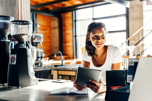 Cafe owner using digital tablet at counter