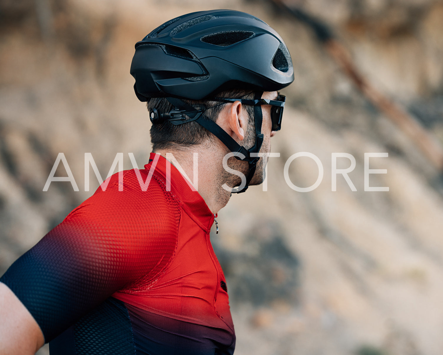 Back view of a cyclist in a black helmet looking away