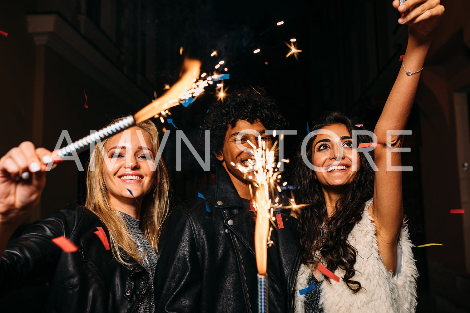 Young people having fun with sparklers outdoors, walking on city street