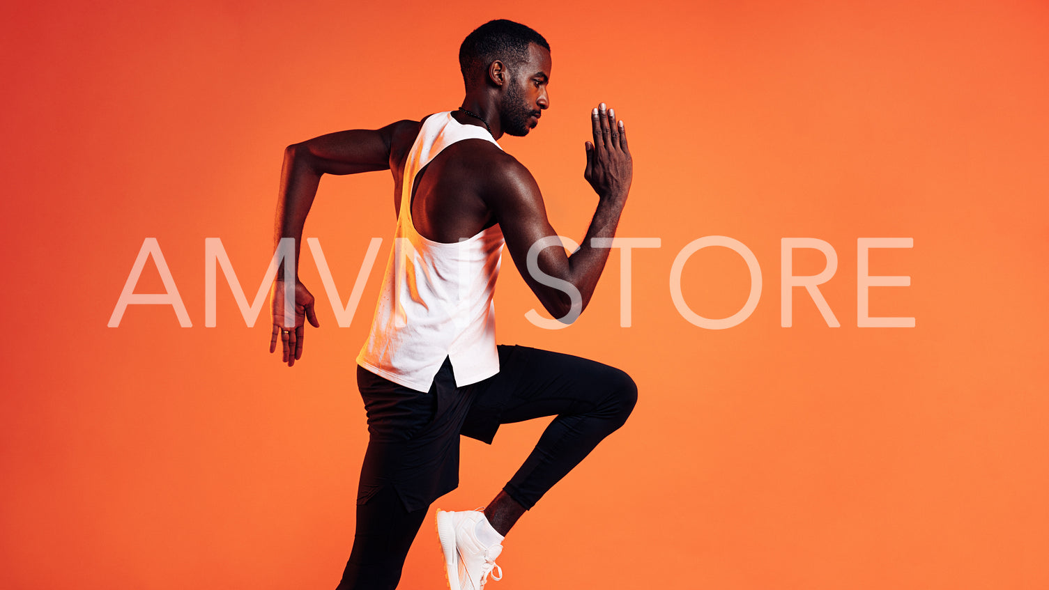 Side view of a male runner sprinting over orange background