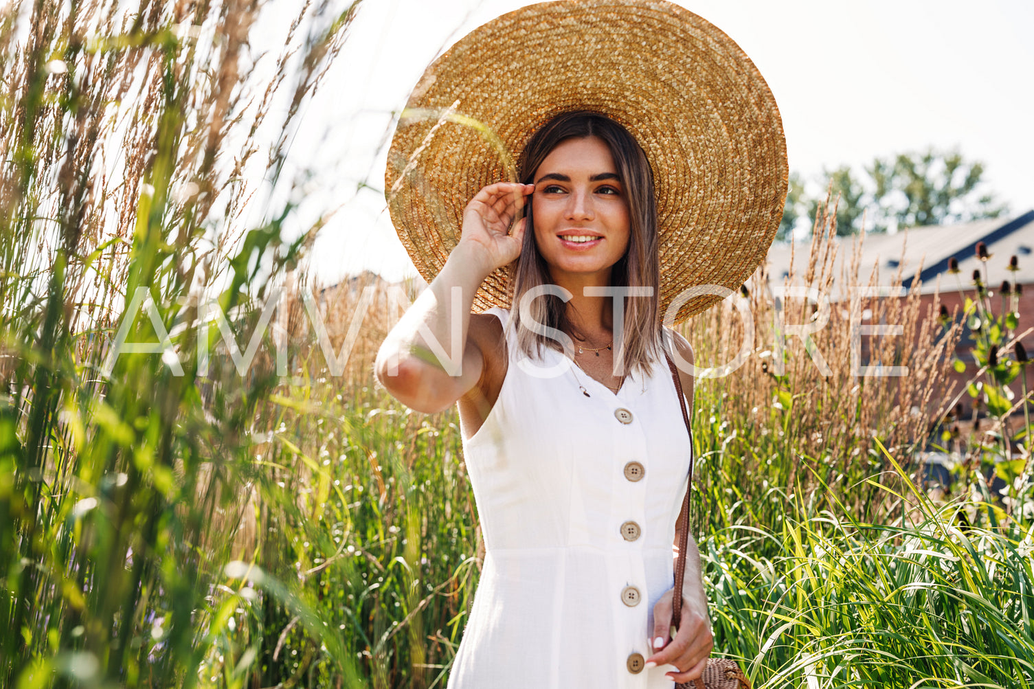 Young stylish woman looking away while standing on a field	