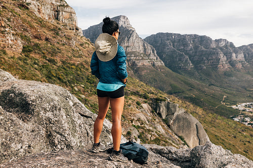 Back view of woman hiker looking at the view from a mountain top