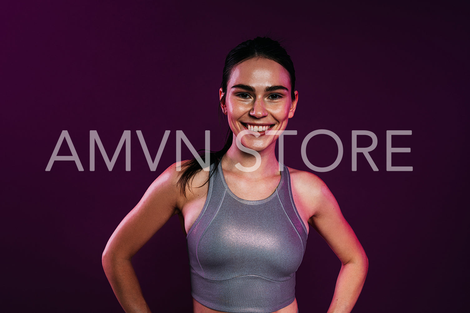 Beautiful smiling woman in silver sportswear against a magenta background