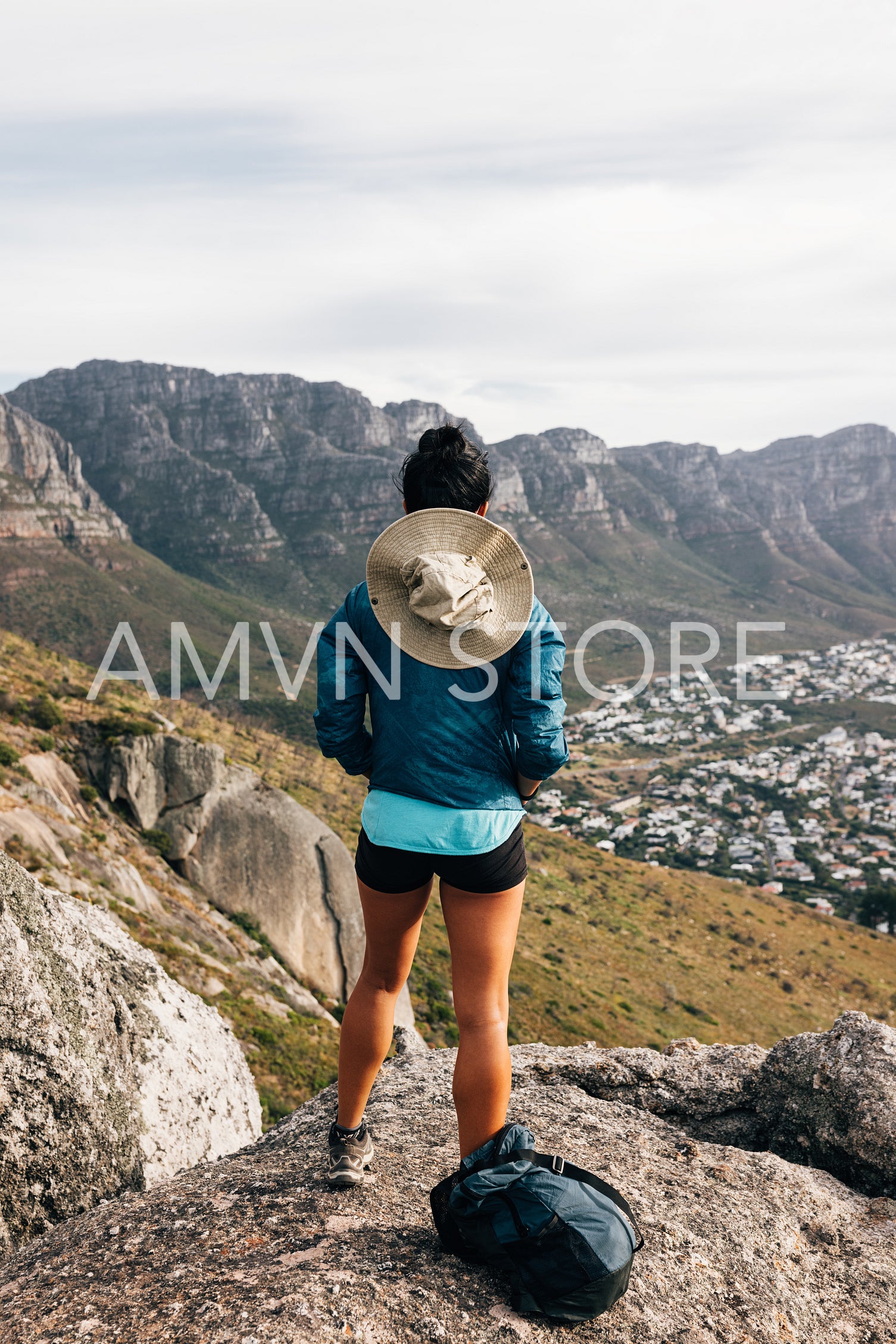 Rear view of young female standing on a mountain top and looking