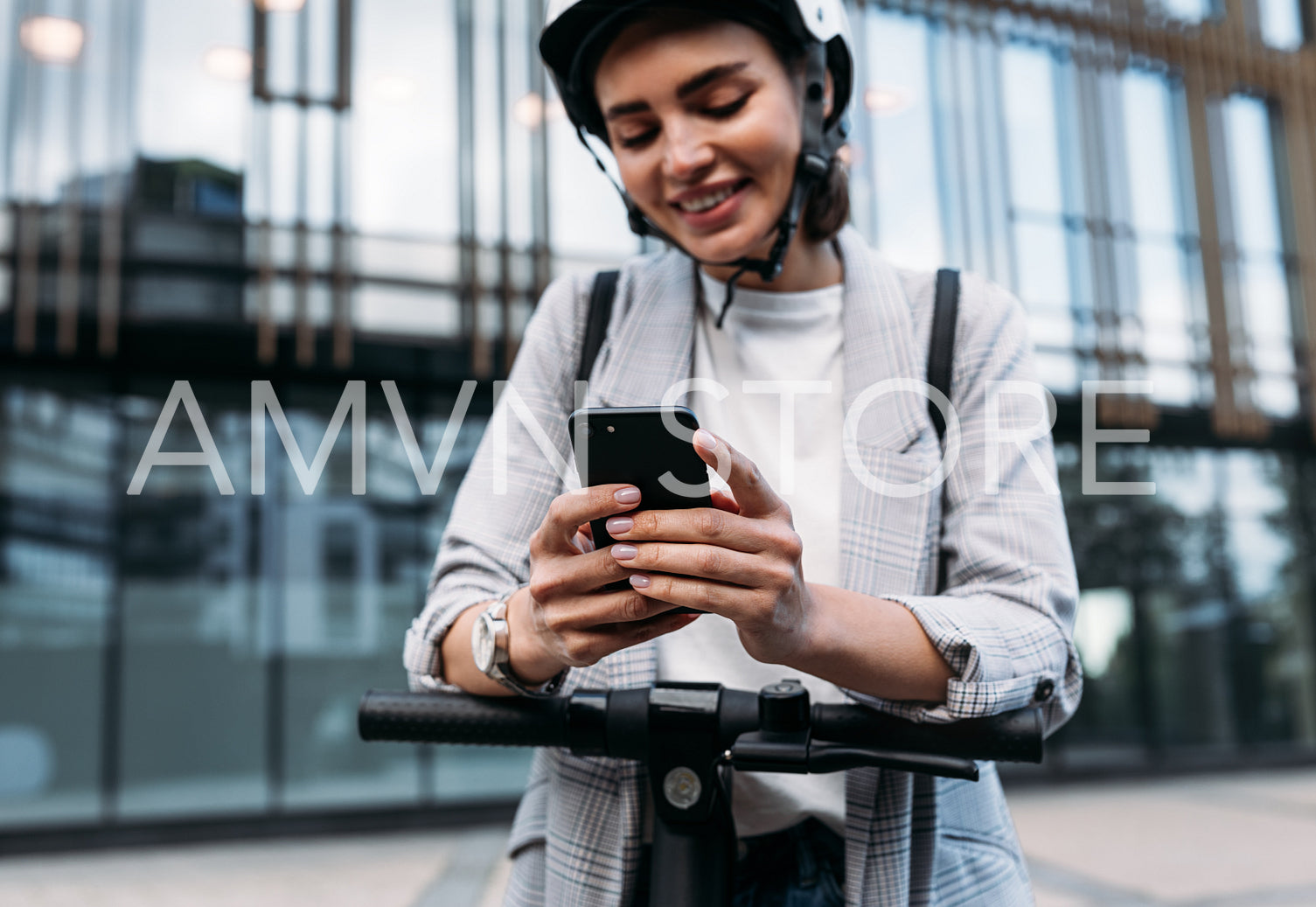 Close up of businesswoman hands holding smartphone while standing on electric scooter