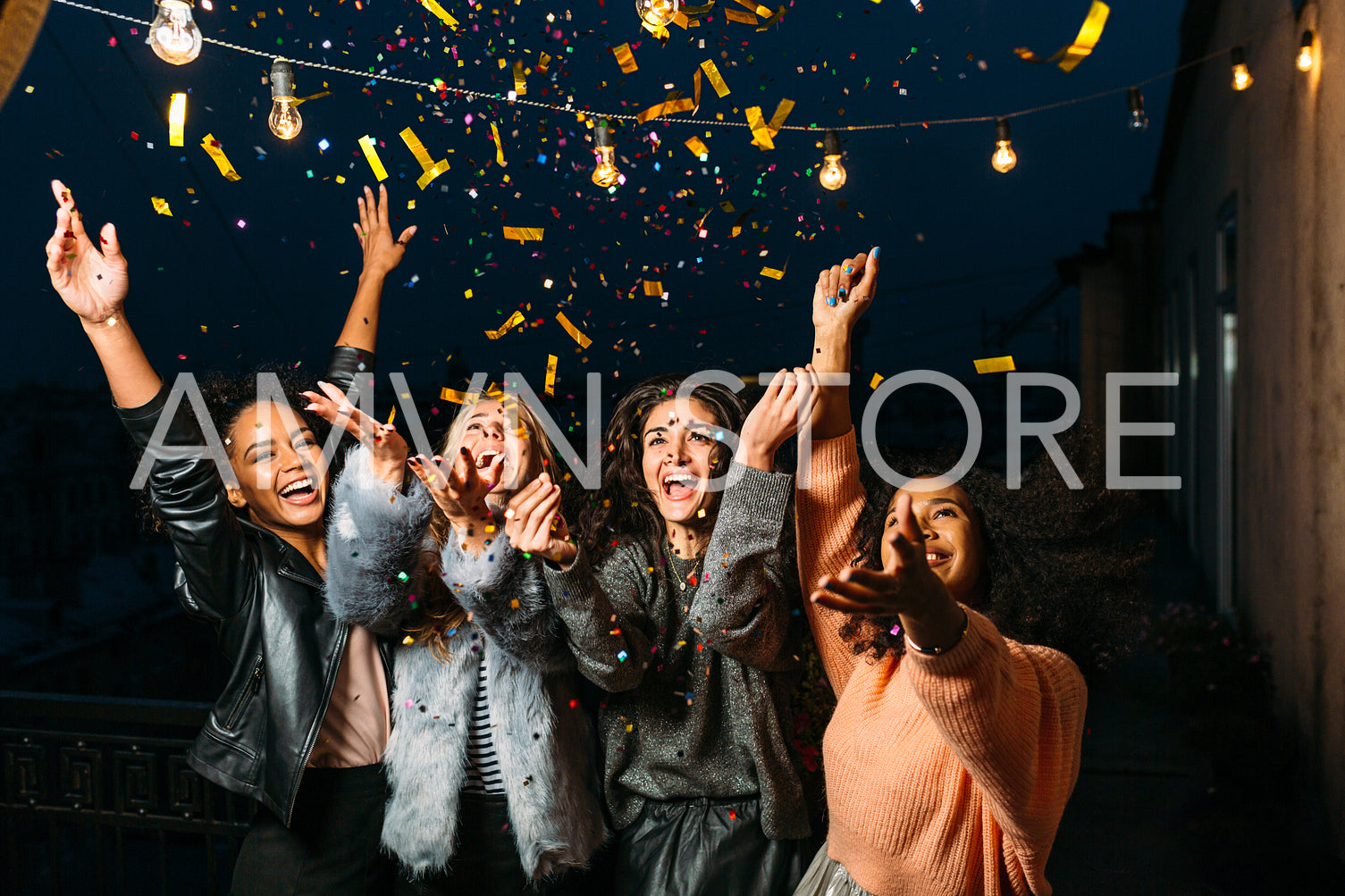 Group of female friends under confetti. Women having fun outdoors.	