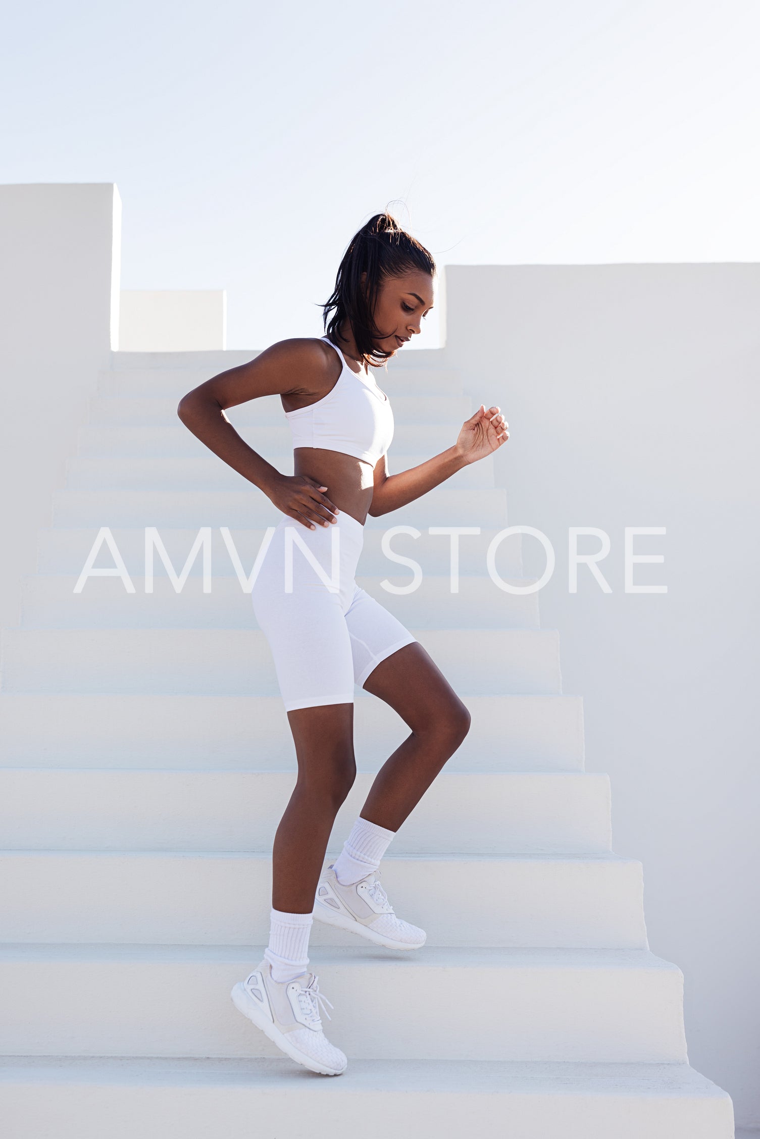 Side view of a slim woman running down on stairs outdoors. Full length of young fitness female practicing outdoors.