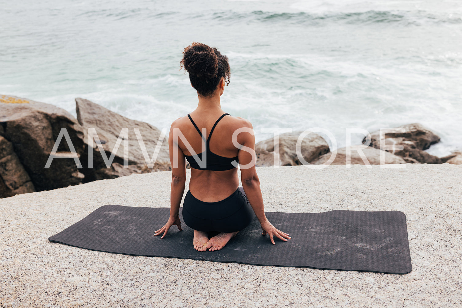 Slim woman sitting on a yoga mat. Female in sportswear relaxing after workout.