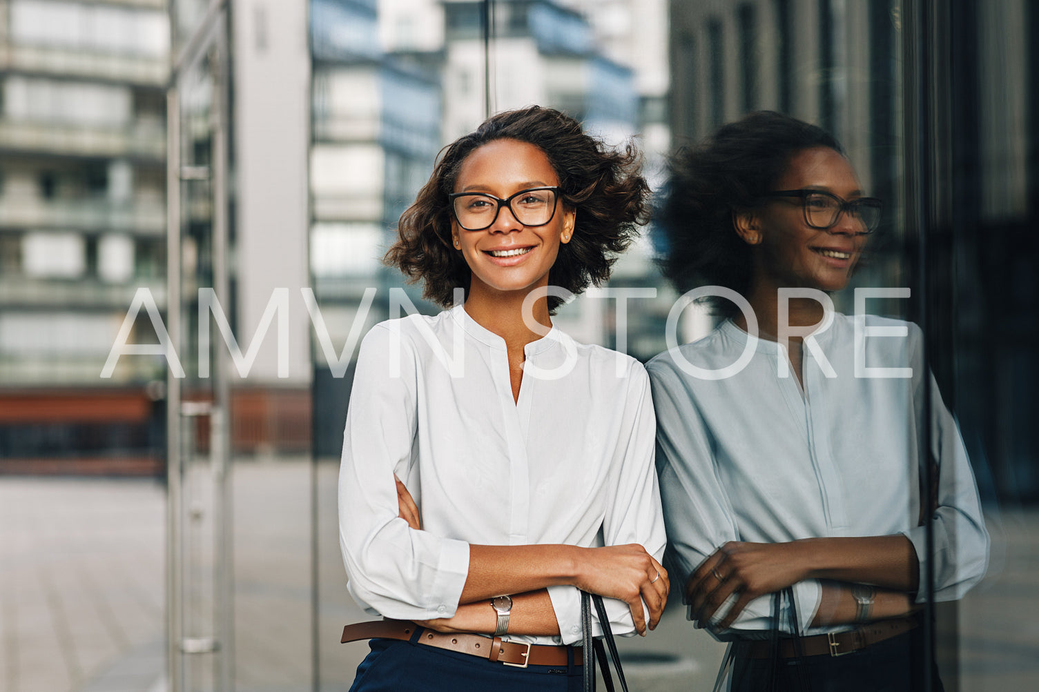 Smiling businesswoman standing outside a office building. Woman in formal wear looking away.