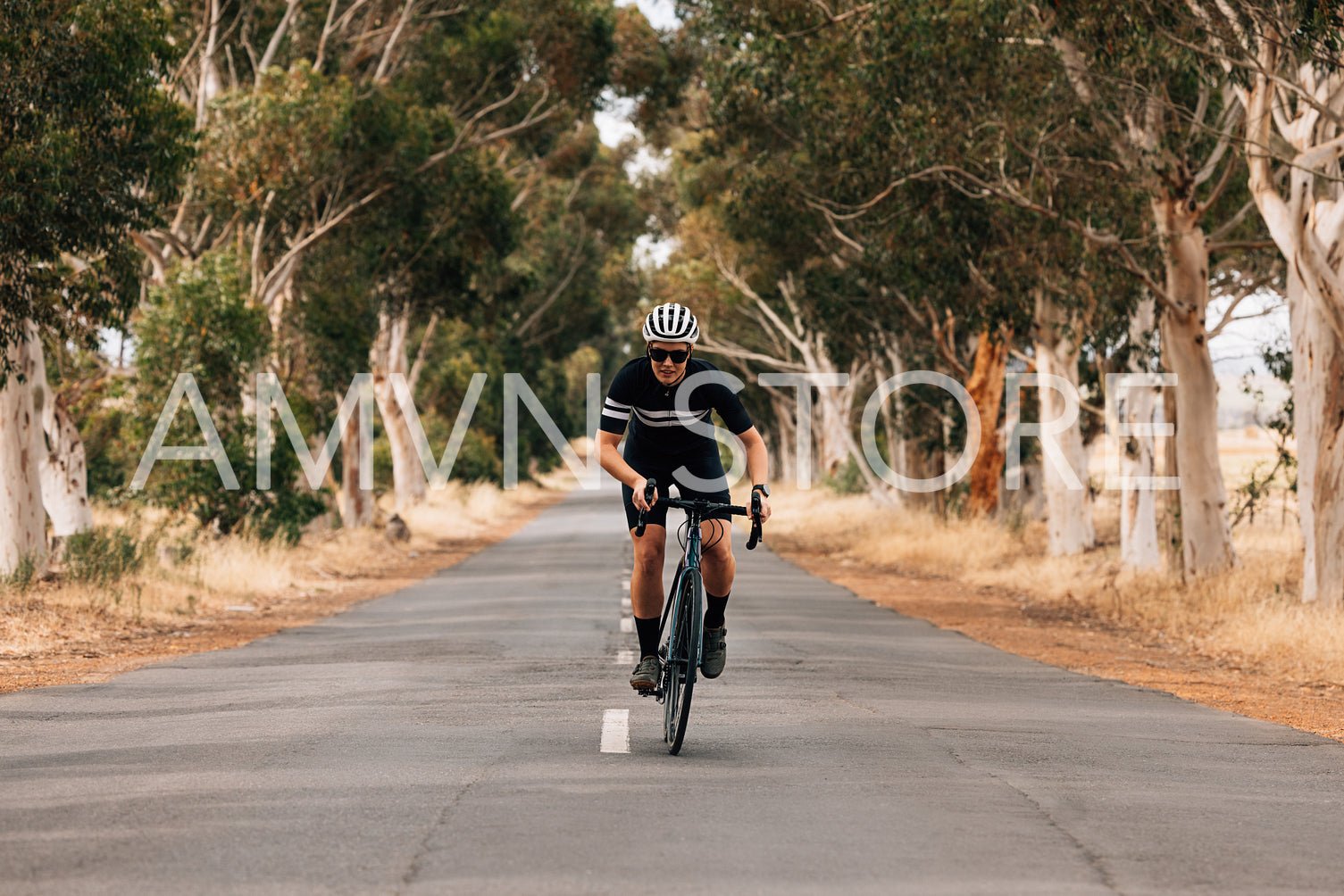 Sportswoman riding a bicycle in the center of an empty road. Pro