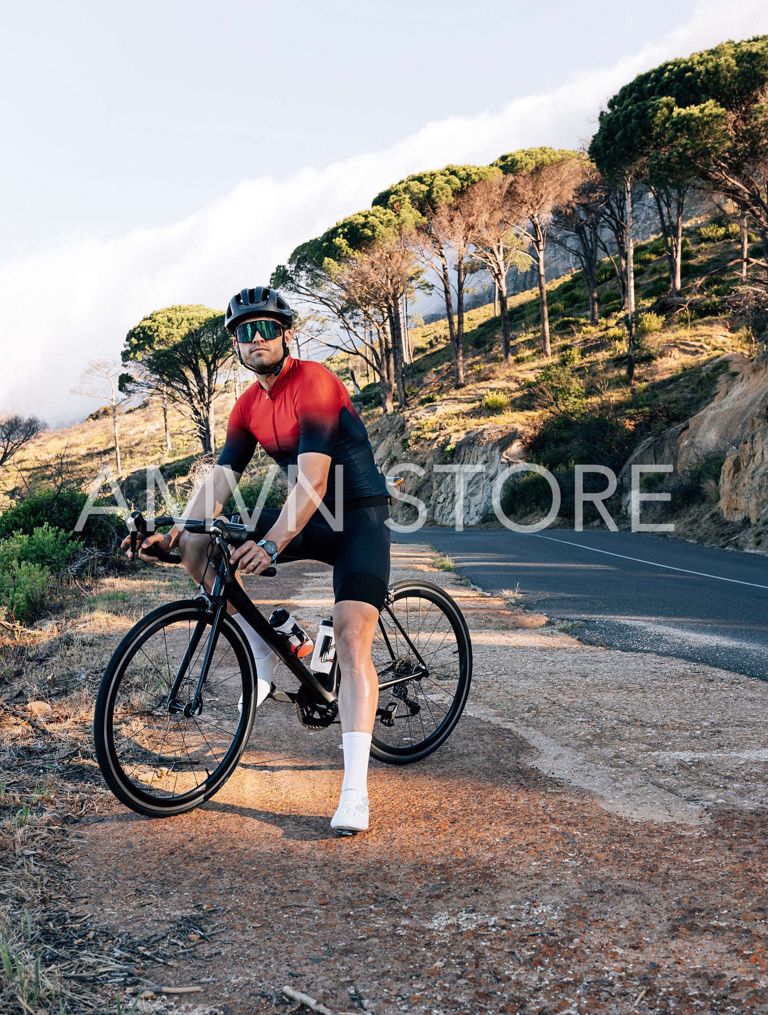 Full length of a bicycle rider with a bike standing on a roadside