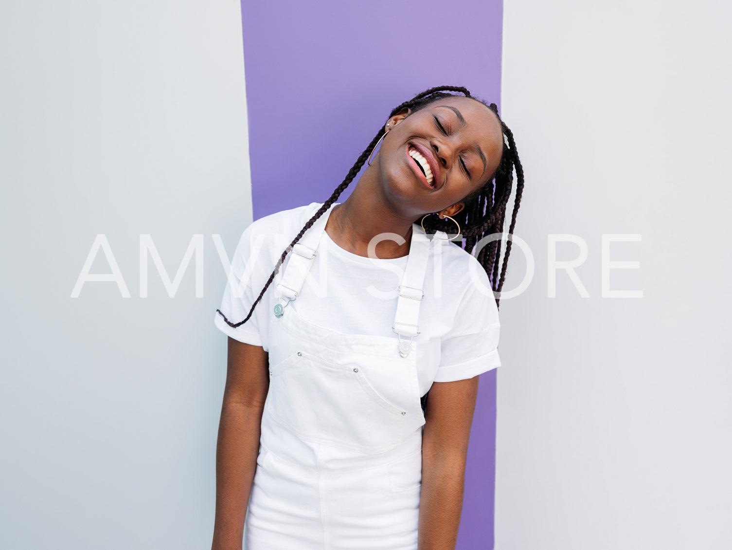 Young cheerful female in white casual clothes standing outdoors a white wall with a magenta stripe