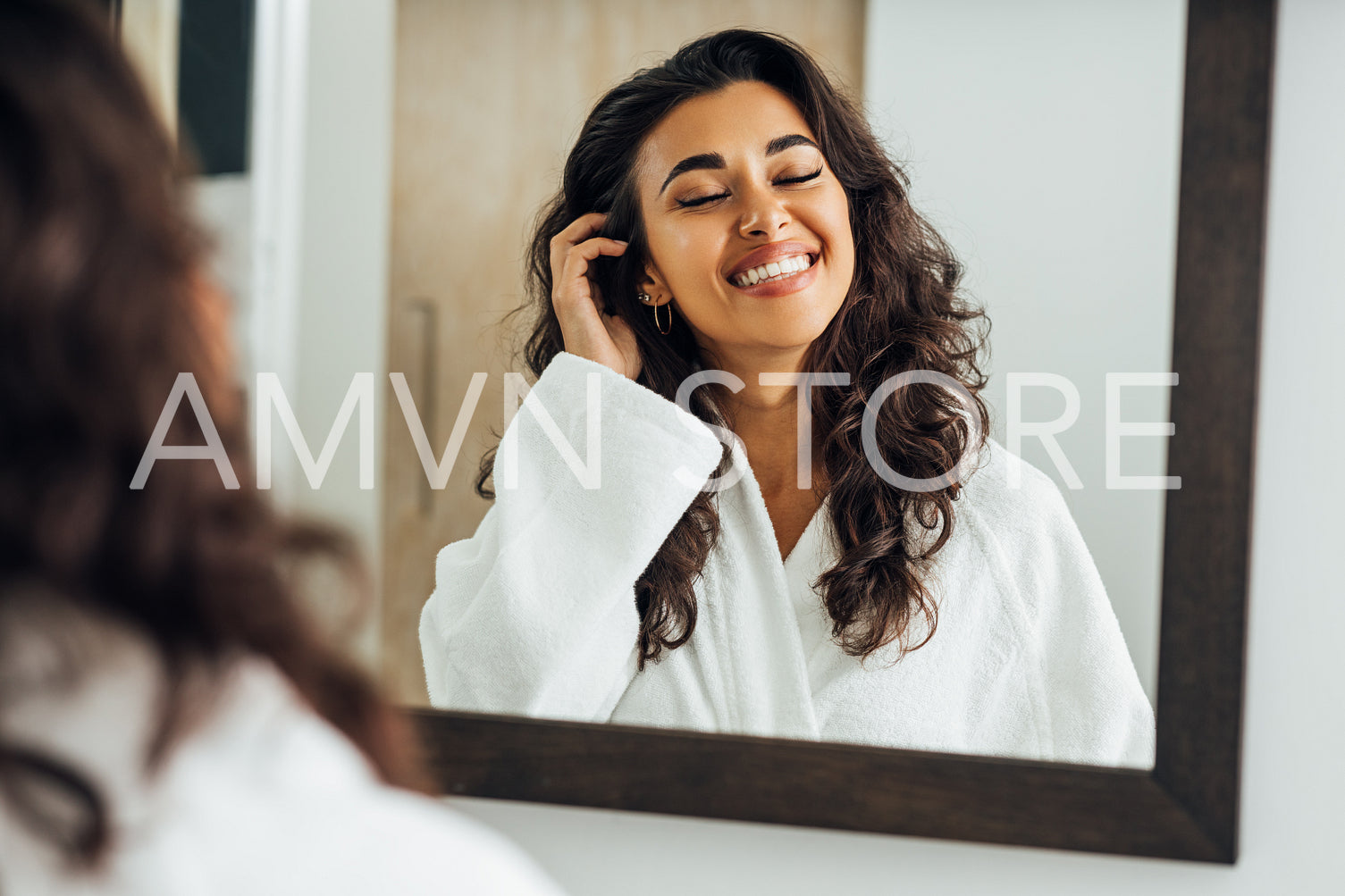 Beautiful middle east woman with closed eyes standing in front of a mirror	