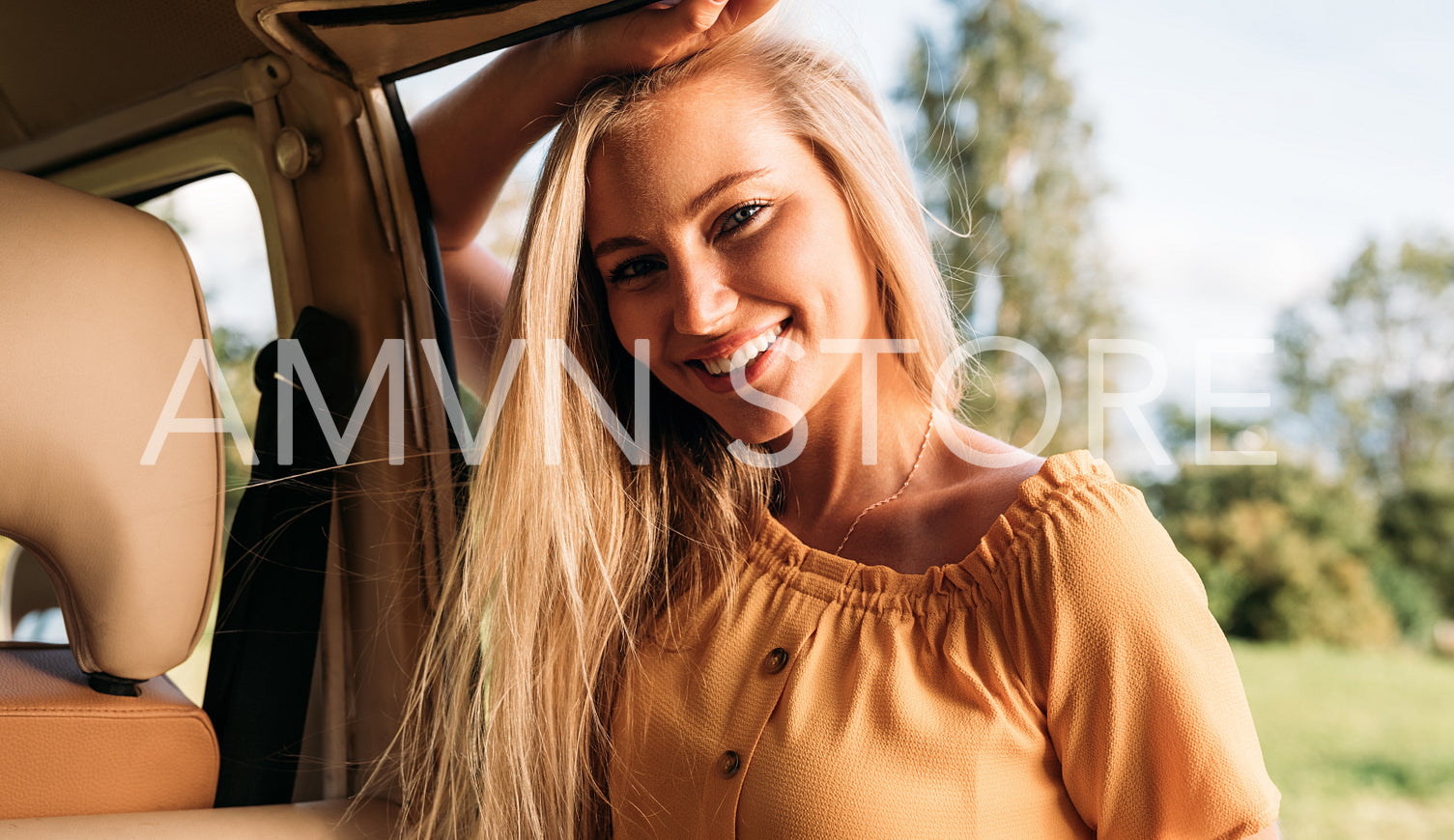 Young cheerful woman looking at camera while standing at a minivan