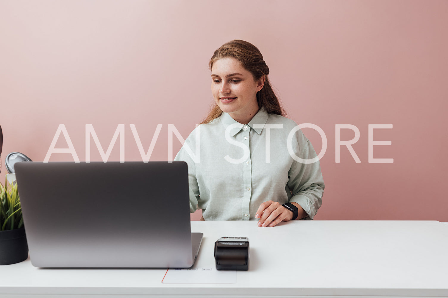 Fashion shop owner standing at counter and working on laptop