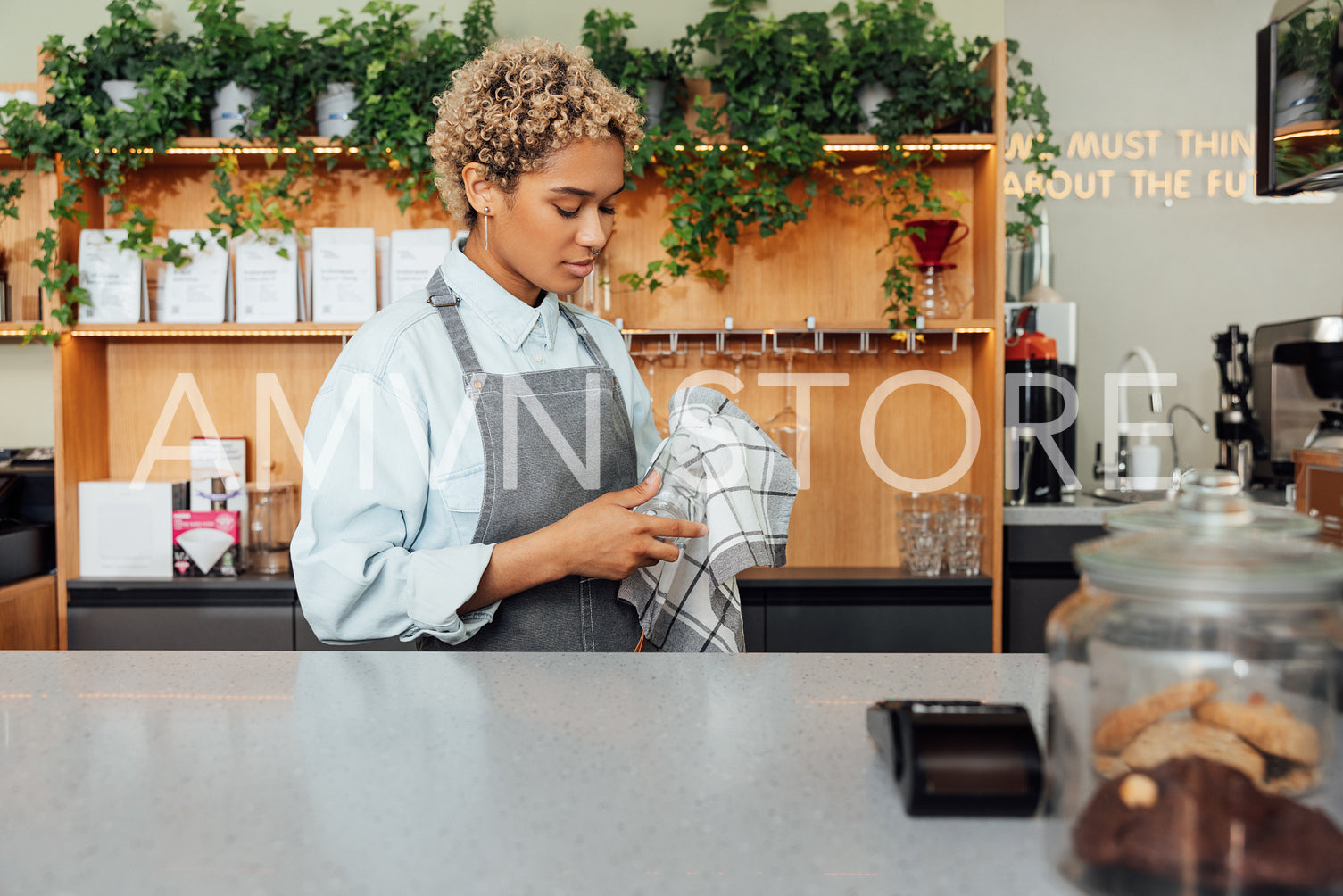 Female bartender wiping glass at counter