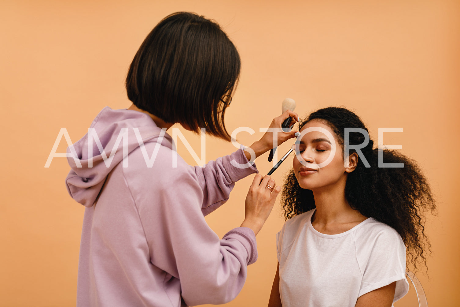 Professional stylist corrects makeup during photo shoot	
