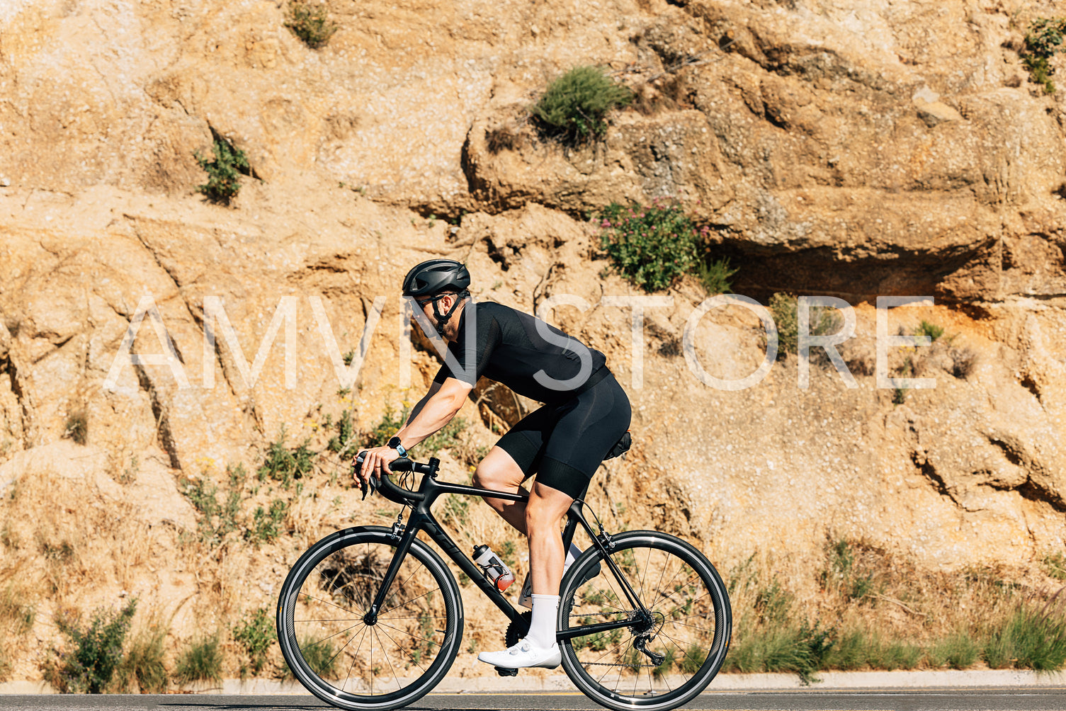 Side view of a male cyclist on a road bike against mountain