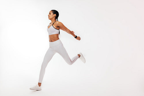 Young mixed race woman running over white background in studio