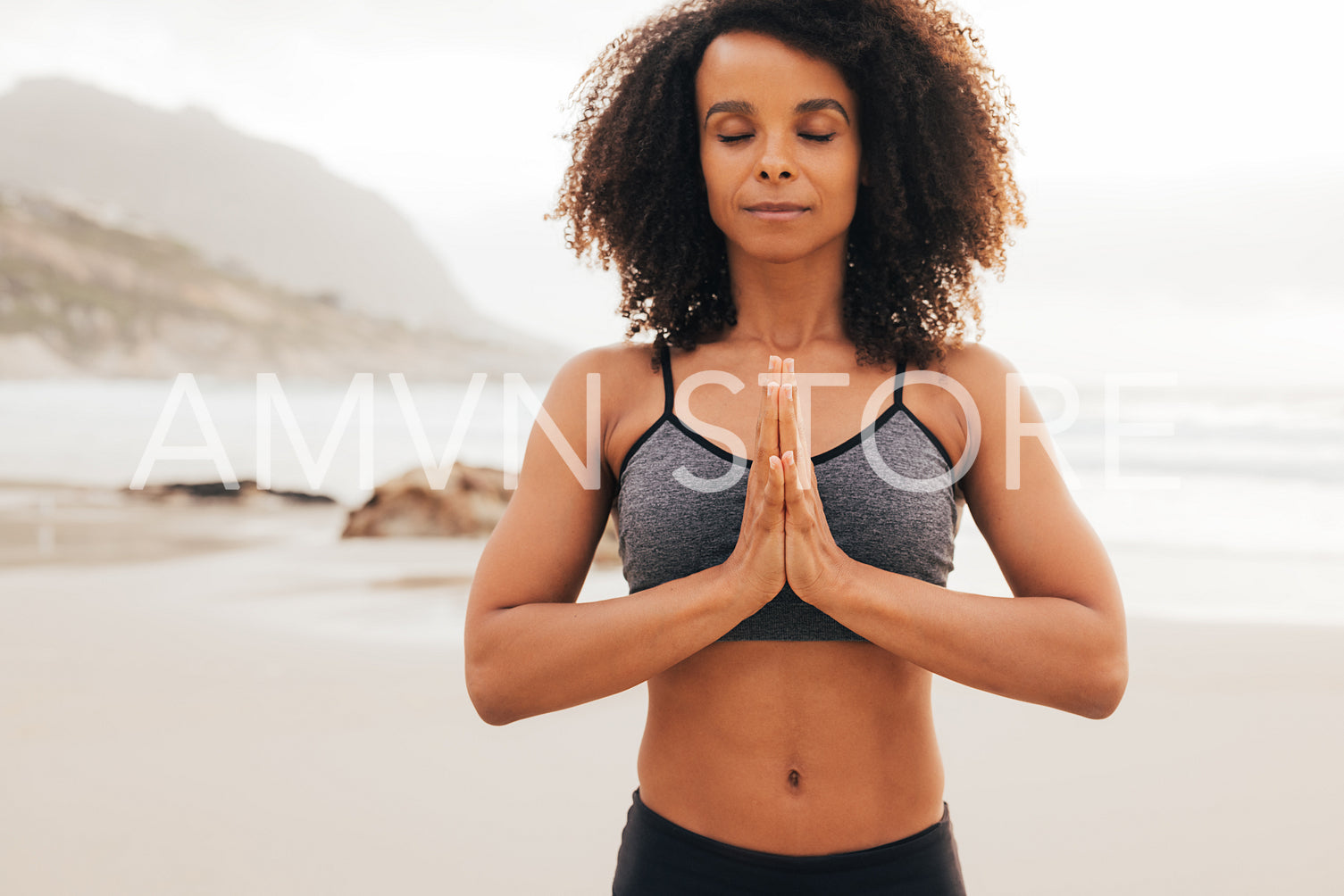 Portrait of fitness woman with her hands joined. Young female with closed eyes practicing yoga meditation.