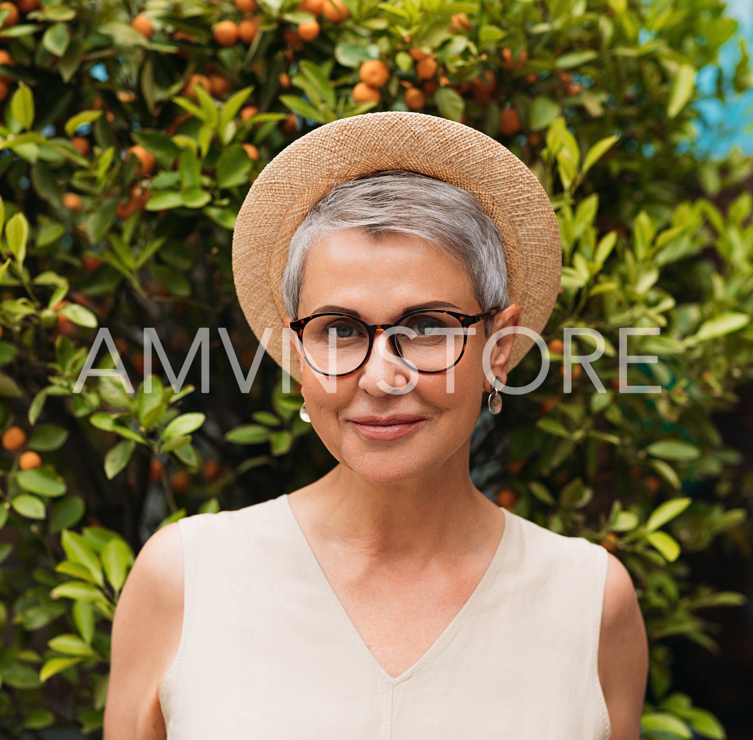 Portrait of a stylish senior woman in eyeglasses and a straw hat 