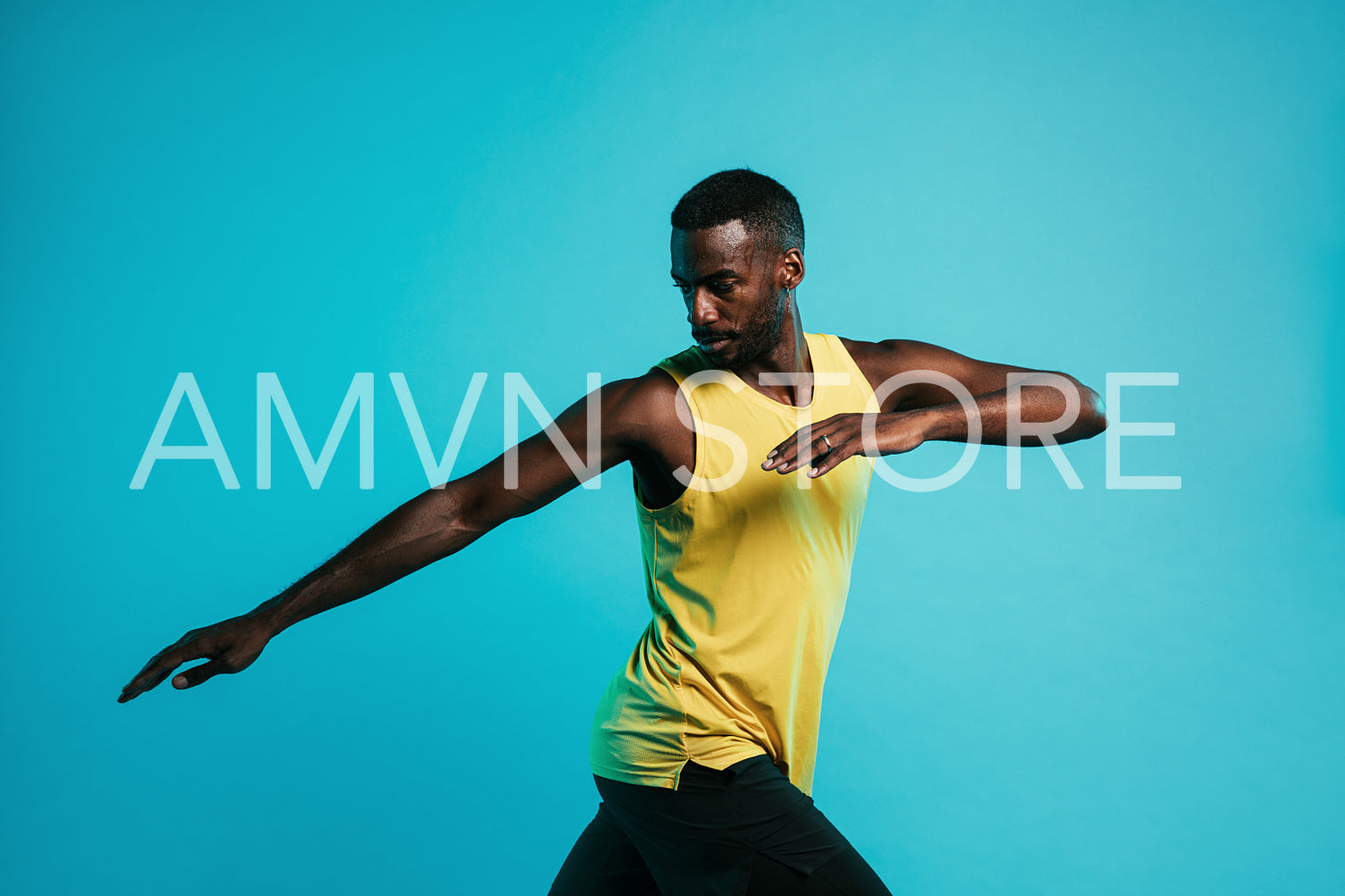 Sportsman doing stretching exercises in studio over blue background