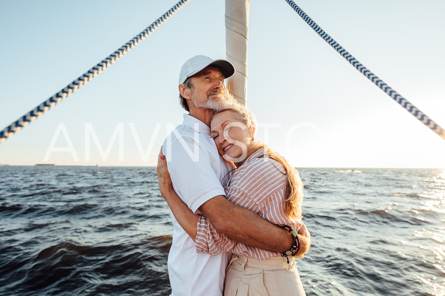 Elderly romantic couple embracing each other on the yacht bow	