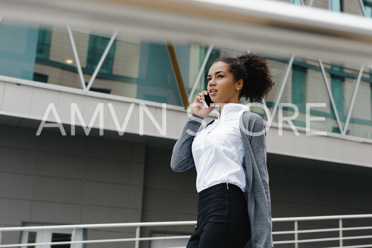 Young businesswoman walking at office building, looking away	