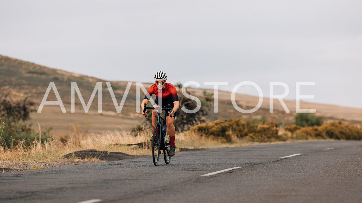 Professional woman cyclist in sportswear practicing on a empty road