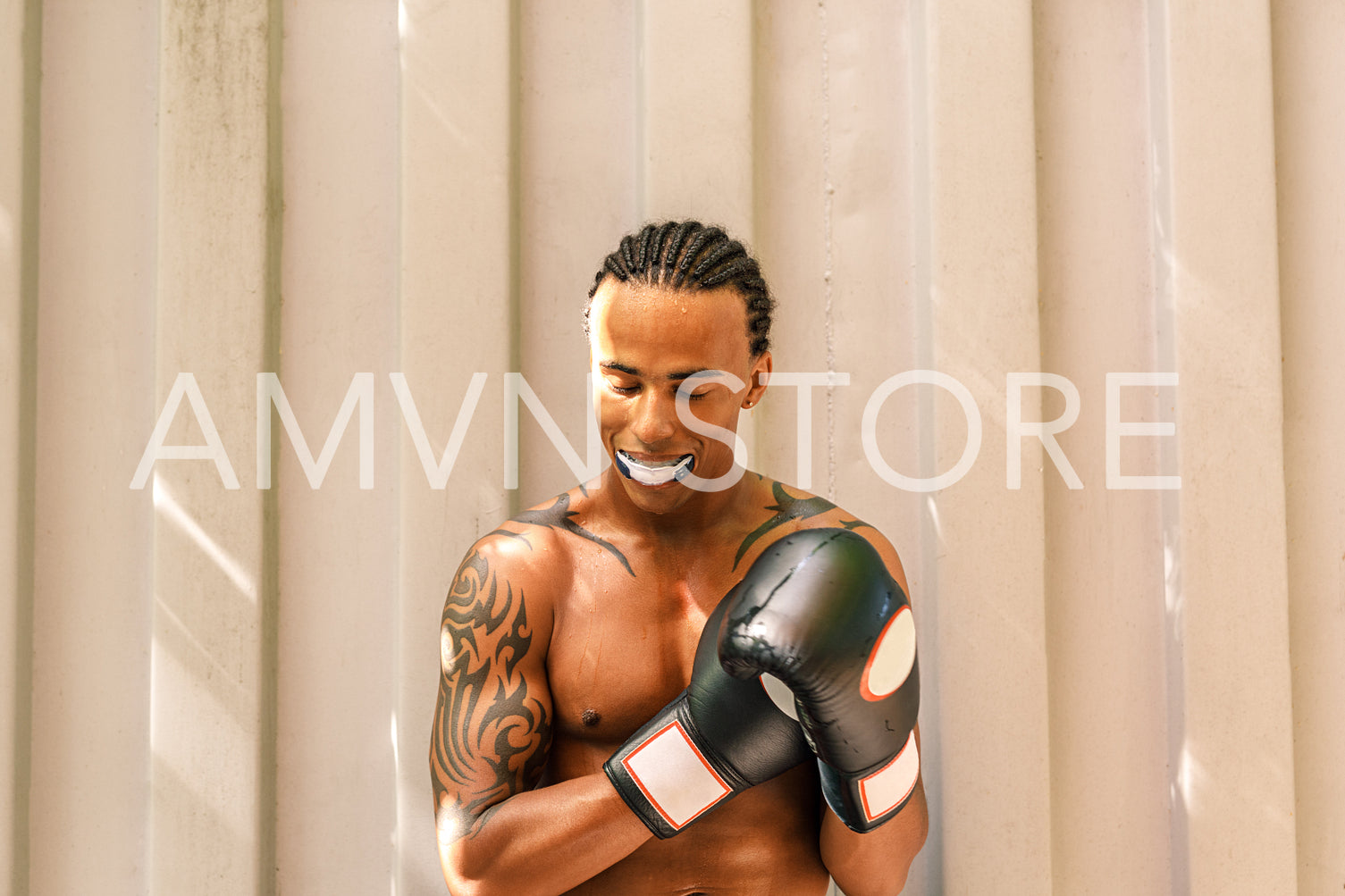 Male boxer with mouth guard outdoors. Tired and sweaty athlete with boxer gloves resting after training.	