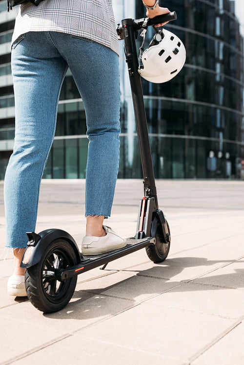 Cropped shot of unrecognizable businesswoman driving electric scooter in the city