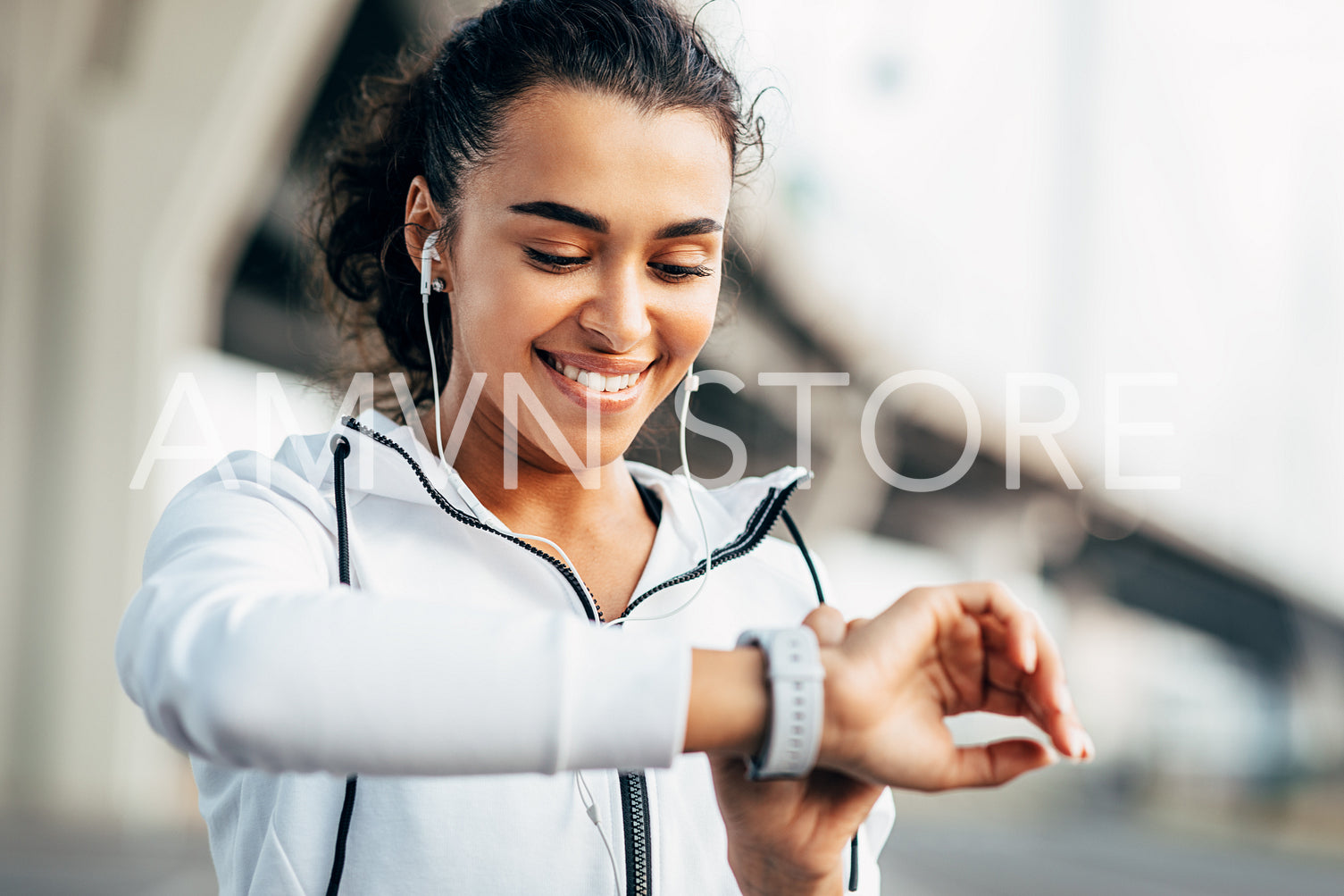 Smiling woman checking her physical activity on smartwatch. Young female athlete looking on activity tracker during training.	