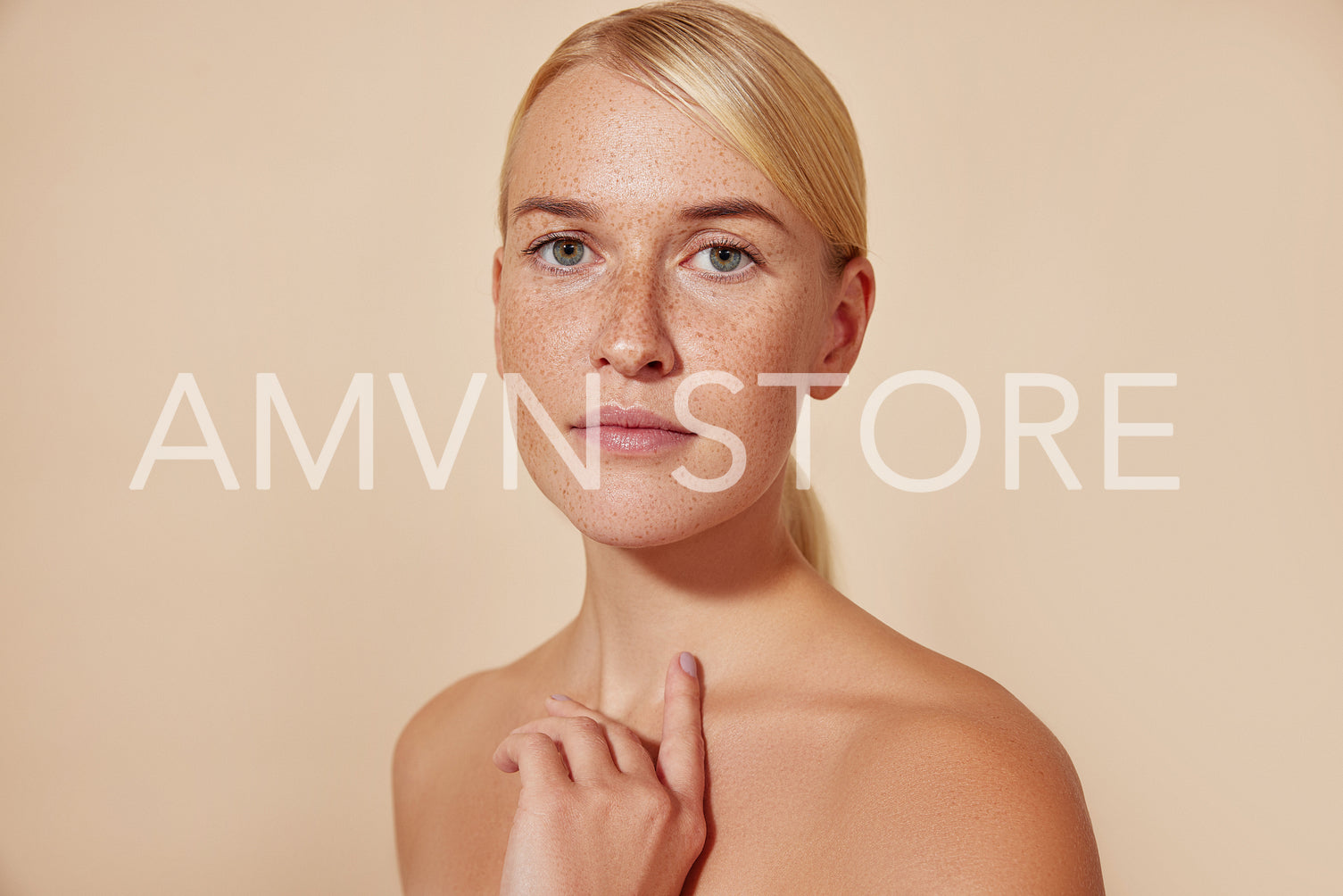 Portrait of a young blond female with freckles against pastel backdrop. Natural beauty woman with smooth skin.