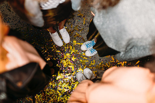 Top shot of four unrecognizable women standing on floor with confetti