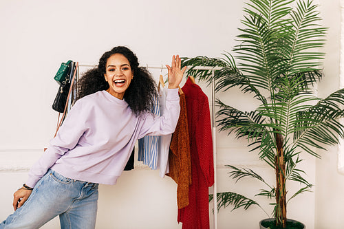 Happy stylist posing in studio. Young blogger greetings her audience.