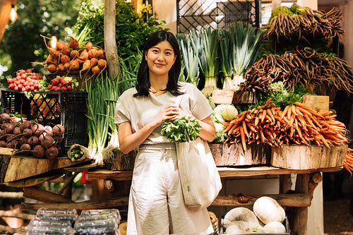 Young woman with a shopping bag on an outdoor market. Female customer on a local market.