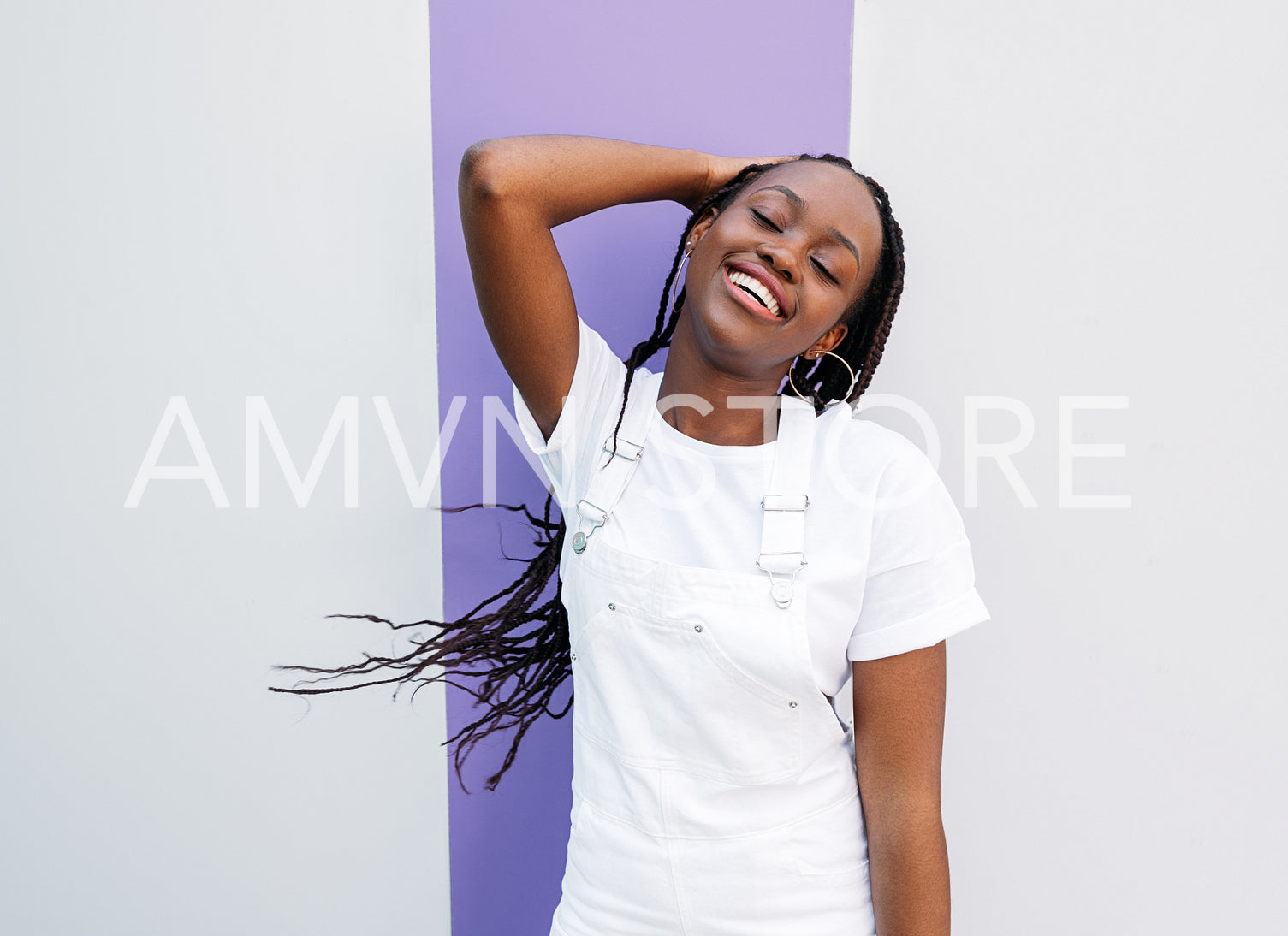 Happy woman with closed eyes adjusting her braids