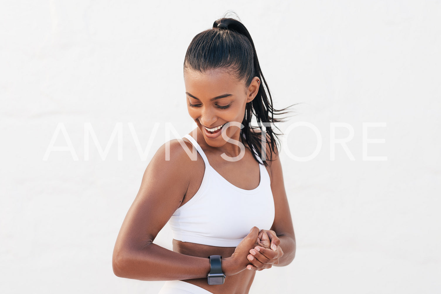 Happy female looking at her bicep. Young fit woman showing her muscles on the arm.