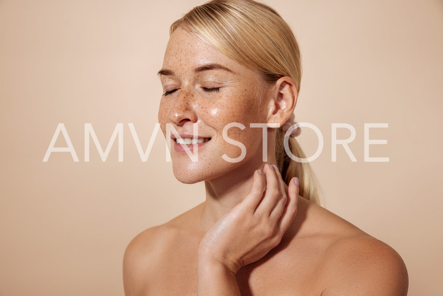 Smiling woman with freckles and perfect skin massaging her neck against pastel background