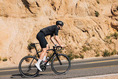 Male cyclist on his road bike doing intense training on an empty road