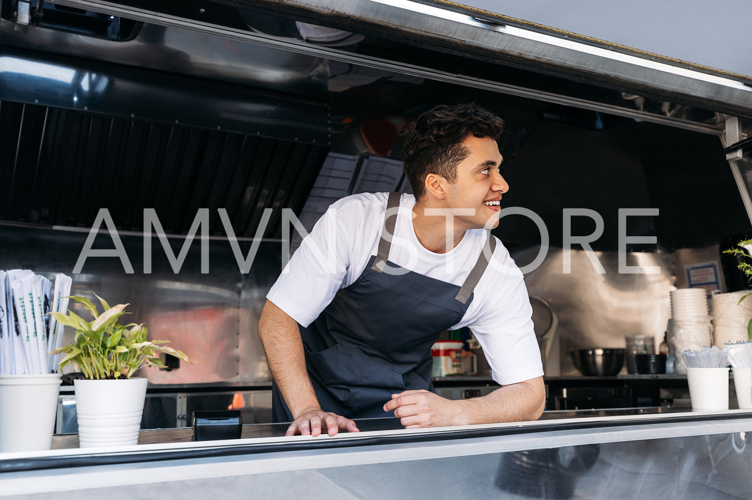 Confident chef in food truck leaning counter. Young food truck owner waiting for customers.