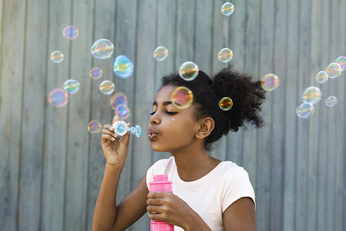 Portrait of cute girl blowing bubbles outdoors