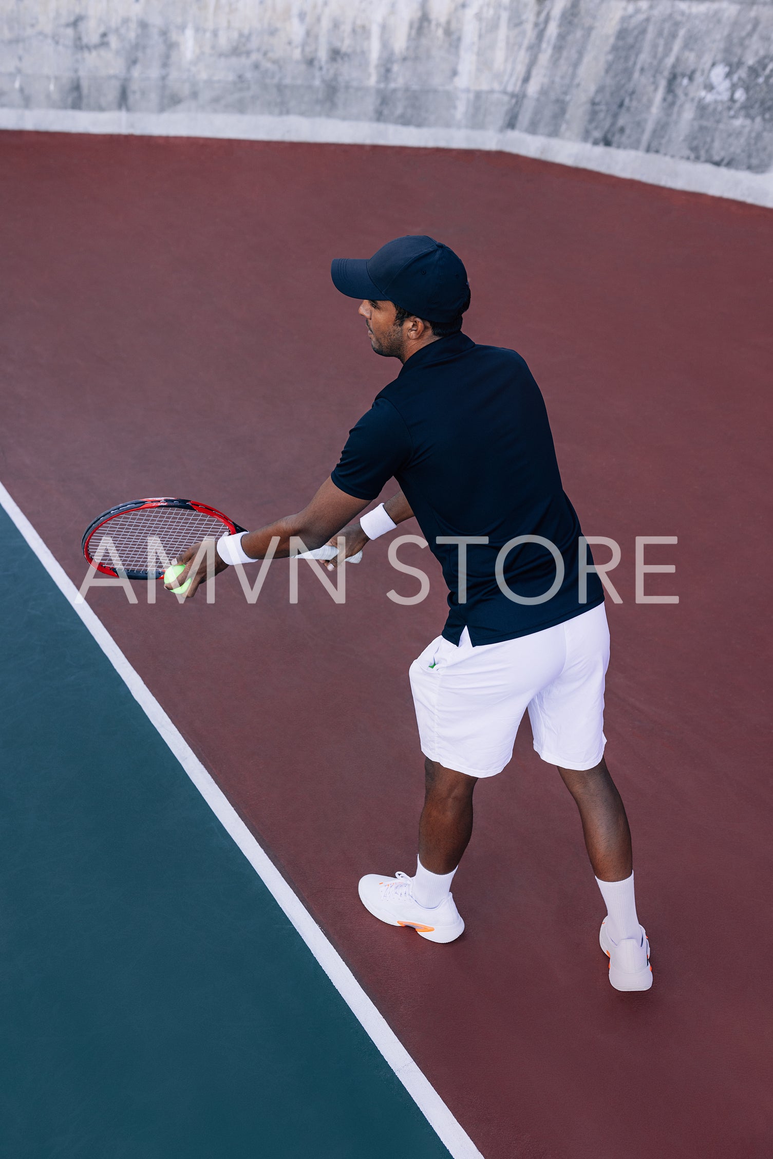 Tennis player with a racket ready to serve a tennis ball standing at the baseline 