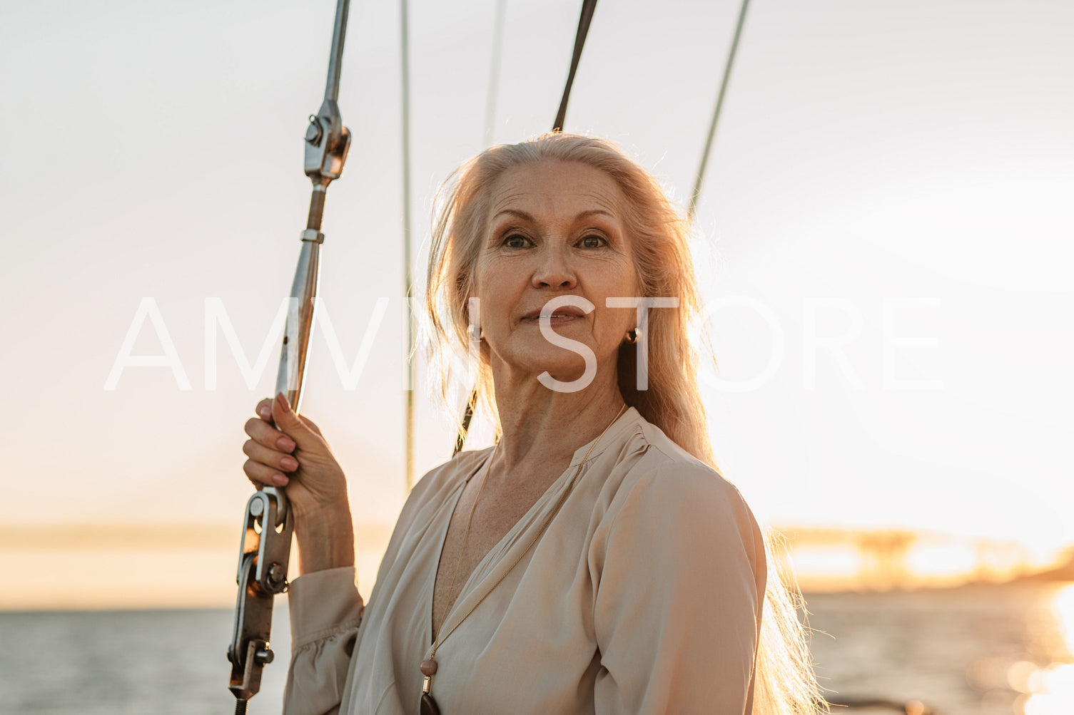 Portrait of stylish mature woman standing on yacht in casuals and looking away	