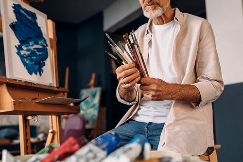 Man working as painter checking brushes before painting