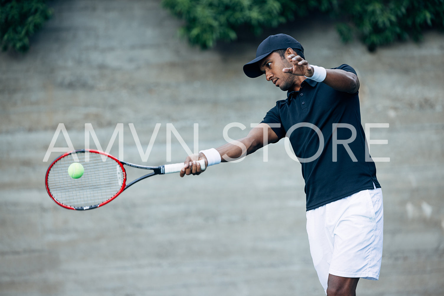 Young tennis player hitting a ball with racket while playing on an outdoor court