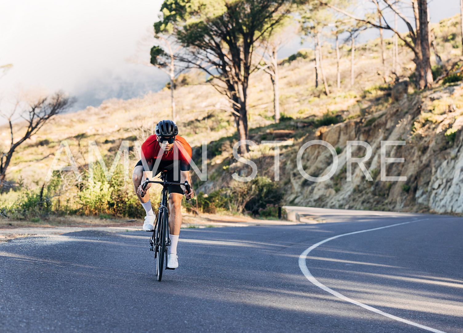 Professional triathlon athlete riding a road bike. Male cyclist riding down his bicycle on an empty road.