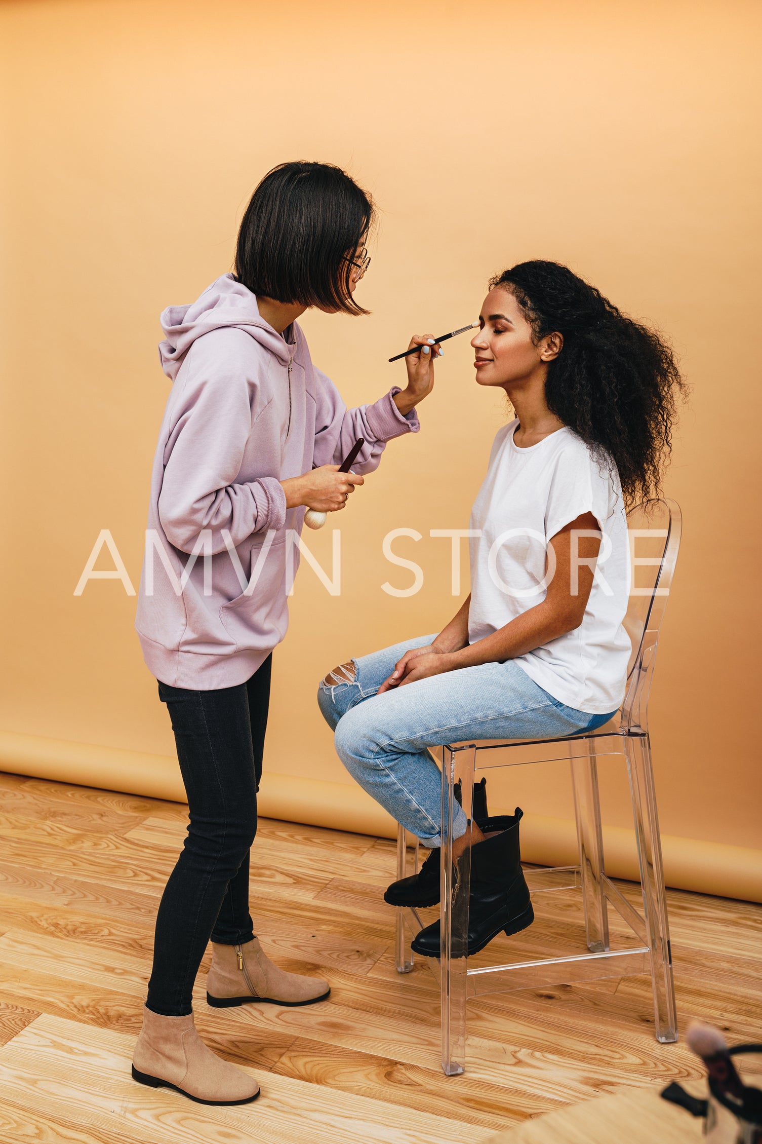 Female artist applying make up on fashion model before photo shoot	
