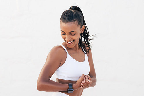 Happy female looking at her bicep. Young fit woman showing her muscles on the arm.